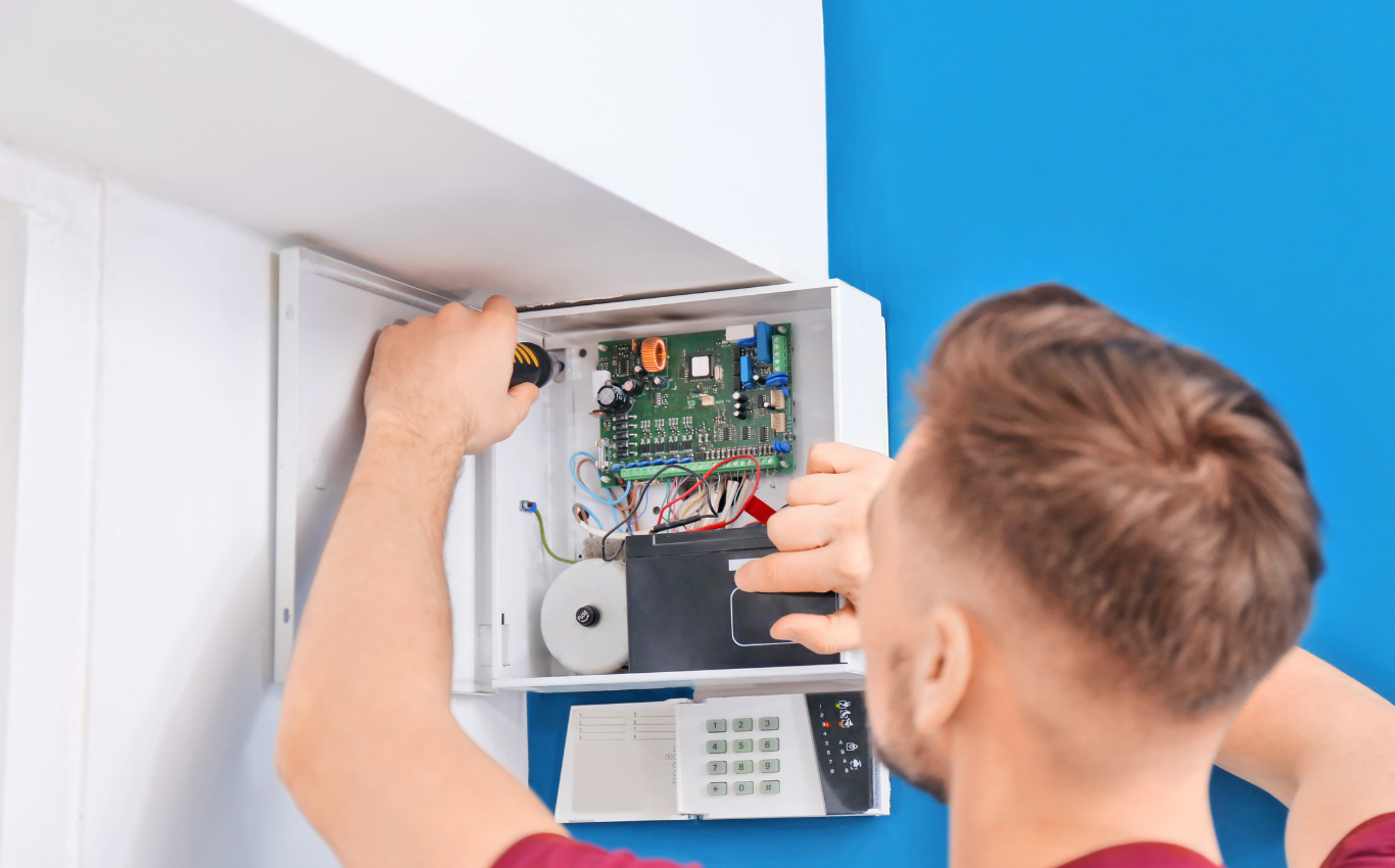 Alarmtekniker arbejder på ABA- og alarmsystem i teknikskab under installation og service.